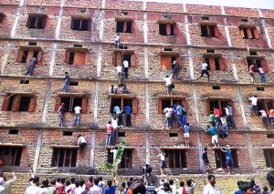 FILE - In this Wednesday, March 18, 2014 file photo, Indians climb the wall of a building to help students appearing in an examination in Hajipur, in the eastern Indian state of Bihar. Education authorities in eastern India say 600 high school students have been expelled after they were found to have cheated on pressure-packed 10th grade examinations. (ANSA/AP Photo/Press Trust of India, File) INDIA OUT
