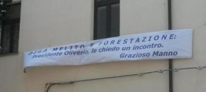 Lo striscione apparso sulla facciata  della sede del Consorzio di bonifica a Catanzaro con il quale il presidente dell'organismo chiede un incontro a Oliverio.