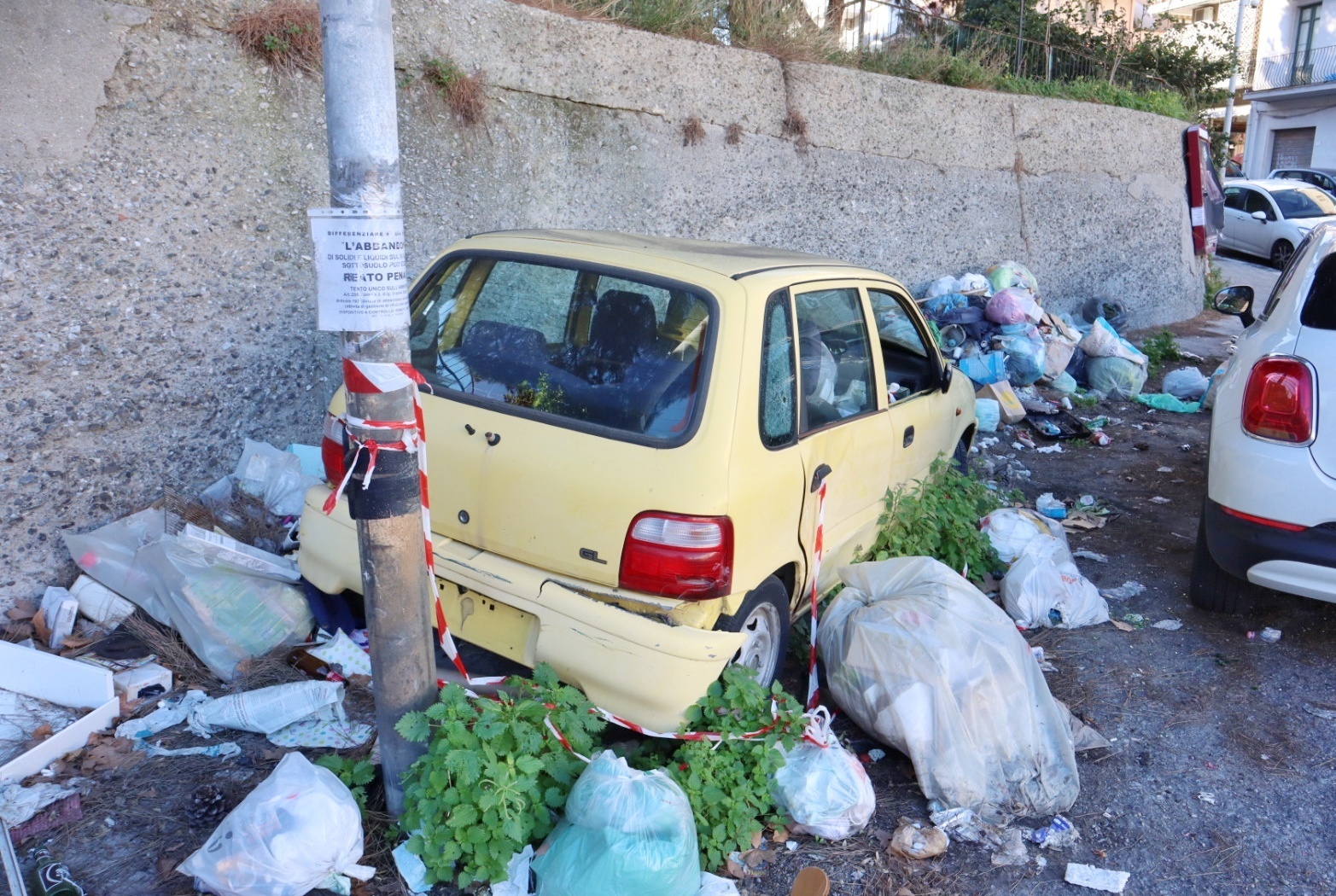 Macchina abbandonata e spazzatura in via Trieste